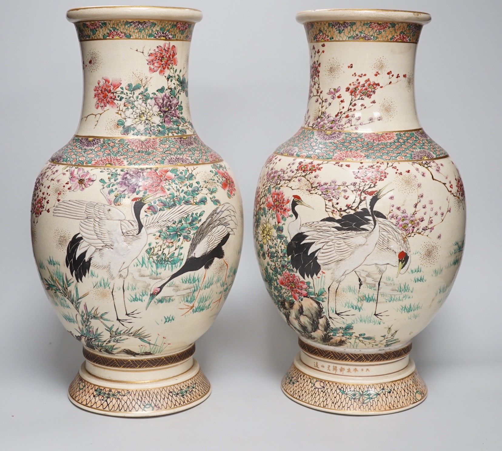 A pair of Japanese Satsuma pottery vases, Meiji period signed above foot, height 38cm